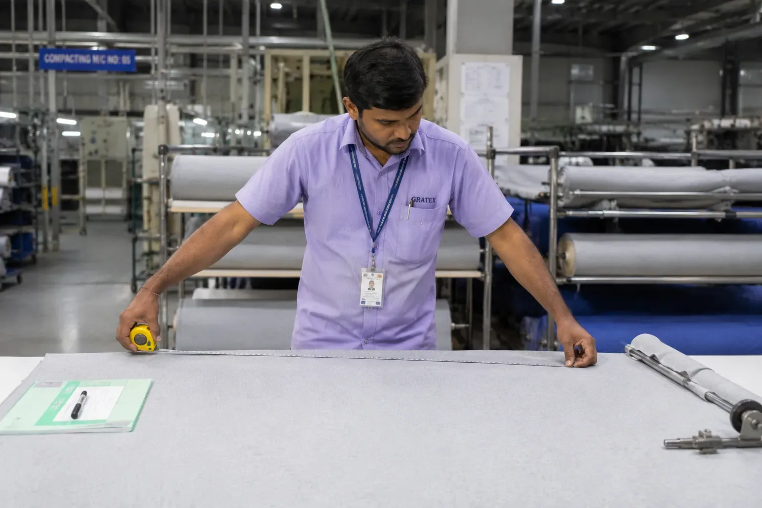 Textile quality inspector checking knitted fabric measurements after the compacting process.